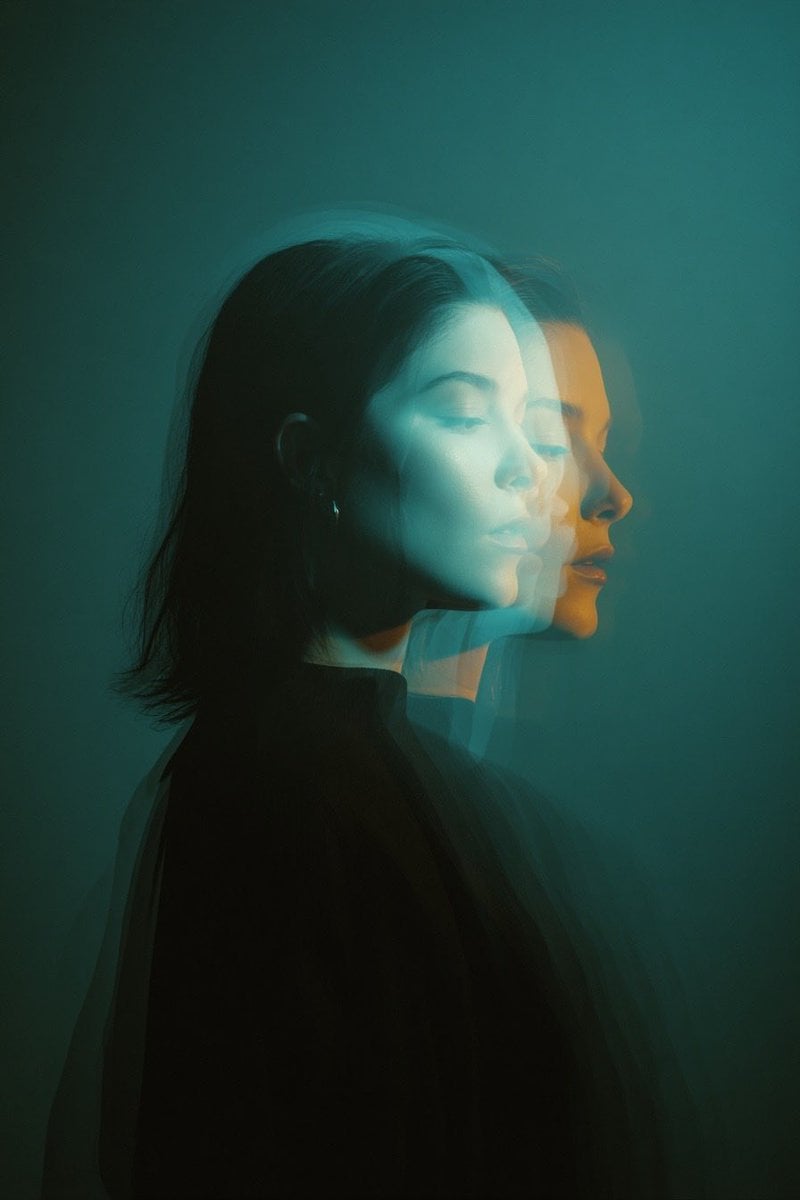 Cinematic double exposure portrait of a woman in side profile, two overlapping faces slightly offset, teal and orange mo