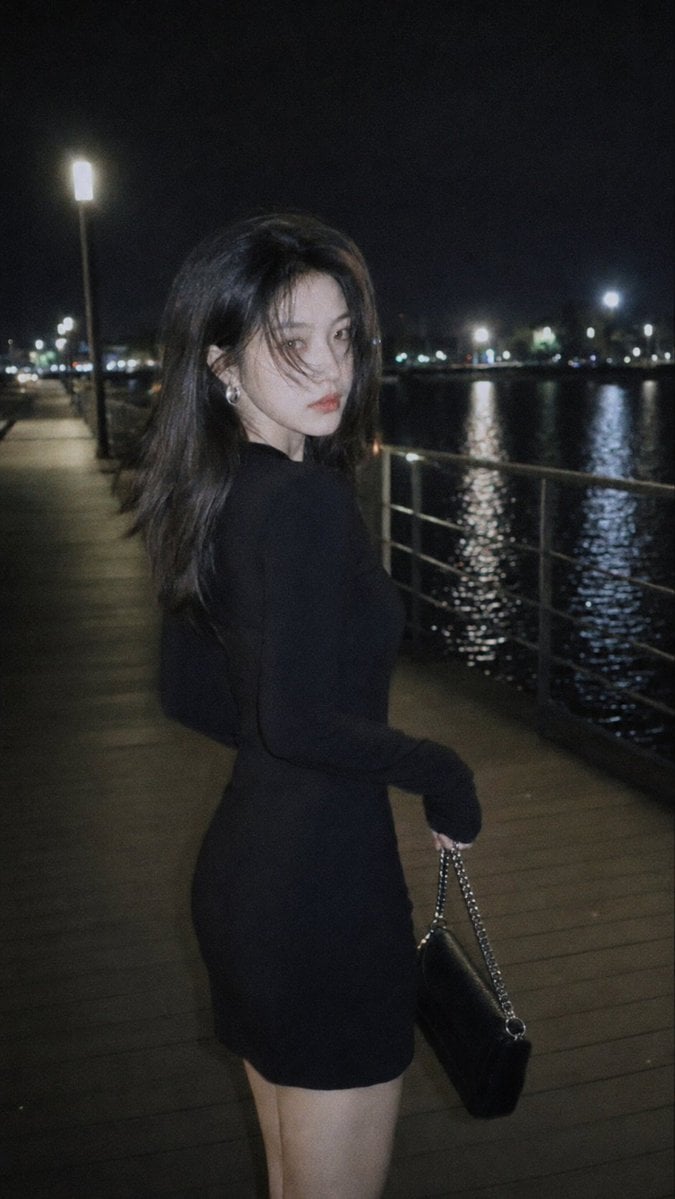 摄影风格：柔光CCD风
写真方向：夜色都市氛围街拍
场景方向：湖边夜间栈道 / 路灯 / 水面倒影 / 栏杆步道
服装方向：黑色长袖修身连衣裙 + 银色耳饰 + 小型链条包
气质标签：清冷、疏离、夜色感、克制、高级、真实抓拍感
五官方向：电