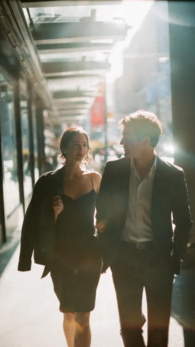 A cinematic candid medium shot portrait of a man and a woman walking side by sid…