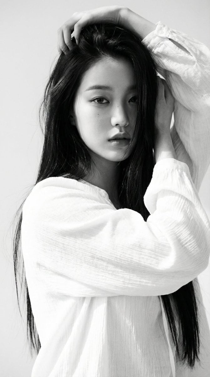 Black-and-white portrait of a young woman with long straight dark hair, wearing …