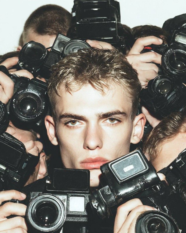 Group of paparazzi taking a photo, frontal view from where they point the lens, …