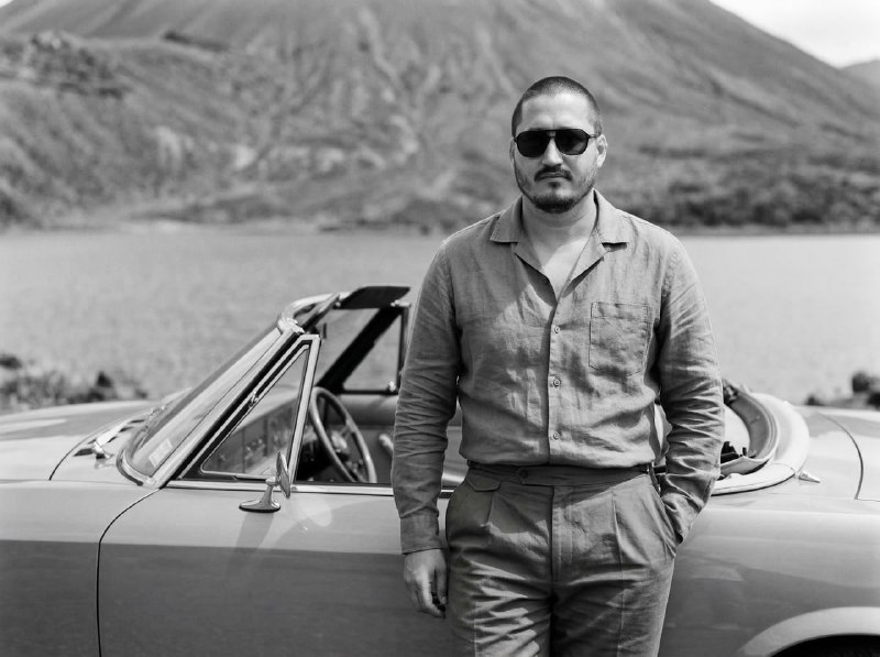Cinematic cowboy shot, knee-up portrait of a stylish man (use the face from the …